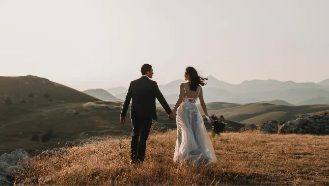 Hochzeitspaar in Landschaft mit Aussicht auf Berge