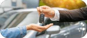 Autofinanzierung - ein Mann übergibt einer Frau einen Schlüssel