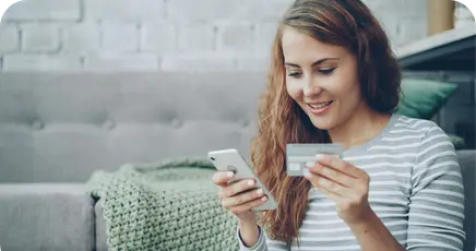 Person mit Kreditkarte und Handy in der Hand